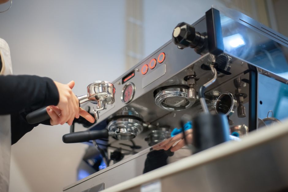 Polaznici tečaja vježbaju pripremu kave uz mentora baristu u učionici